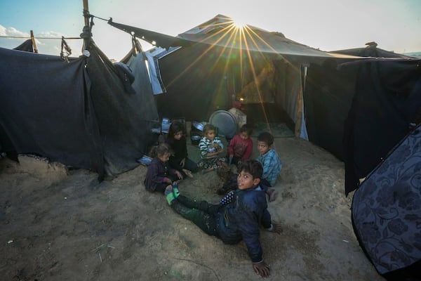 Grandchildren of Reda Abu Zarada, displaced from Jabaliya in northern Gaza, play next to their tent at a camp in Khan Younis, Gaza Strip, Thursday, Dec. 19, 2024. (AP Photo/Abdel Kareem Hana)