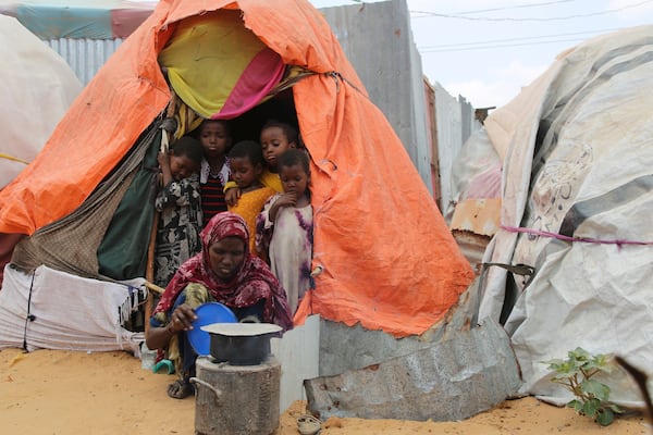 A Somali internally-displaced person (IDP) woman prepares a meal outside her makeshift home in Maslah camp on the outskirts of Mogadishu, Somalia Wednesday, Feb. 5, 2025. (AP Photo/Farah Abdi Warsameh)