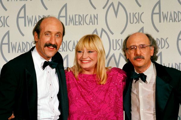 FILE - Folk trio Peter, Paul and Mary, from left, Paul Stookey, Mary Travers and Peter Yarrow, appear at the American Music Awards in Los Angeles, Jan. 26, 1987. (AP Photo/Lennox McLendon, File)