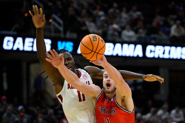 Alabama center Clifford Omoruyi, left, and Saint Mary's center Mitchell Saxen (11) reach for the ball in the second half in the second round of the NCAA college basketball tournament, Sunday, March 23, 2025, in Cleveland. (AP Photo/David Richard)