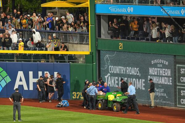 A fan is carted off the field at PNC Park after falling out of the stands during the seventh inning of a baseball game between the Pittsburgh Pirates and the Chicago Cubs in Pittsburgh, Wednesday, April 30, 2025. (AP Photo/Gene J. Puskar)