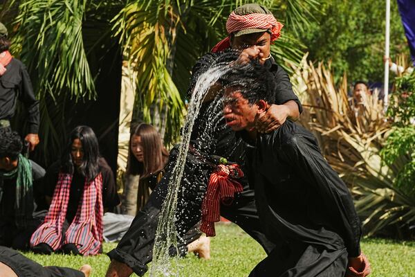 Cambodian students from Royal University of Fine Arts reenact a torture by immersing the head in water, by the Khmer Rouge during their reign of terror in the 1970s in an event hosted by the ruling Cambodian People's Party to mark the annual of Remembrance Day at Choeung Ek, a former Khmer Rouge "killing field," on the outskirt of Phnom Penh, Cambodia Tuesday, May 20, 2025. (AP Photo/Heng Sinith)