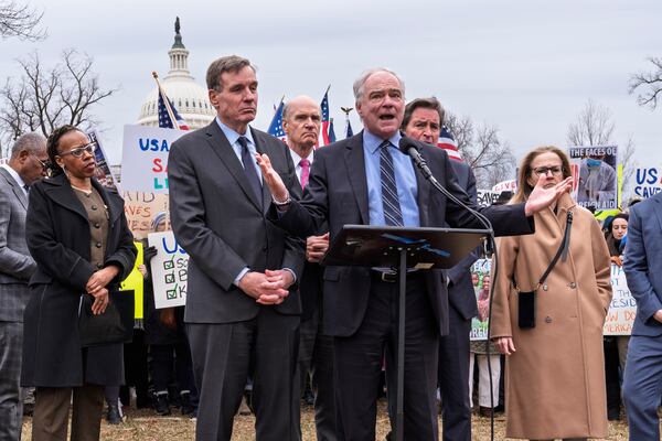 Demonstrators and lawmakers, including Sen. Mark Warner, D-Va., left, and Sen. Tim Kaine, D-Va., rally against President Donald Trump and his ally Elon Musk as they disrupt the federal government, including dismantling the U.S. Agency for International Development, which administers foreign aid approved by Congress, on Capitol Hill in Washington, Wednesday, Feb. 5, 2025. (AP Photo/J. Scott Applewhite)