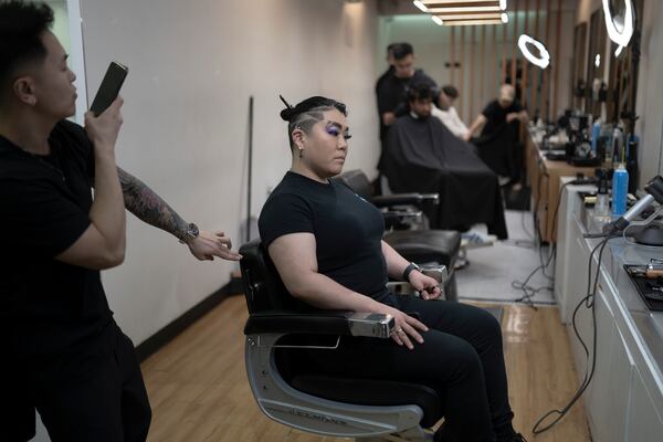 Barbers work on their clients at 12 Pell, a local barbershop in Manhattan's Chinatown, Thursday, Jan. 25, 2024, in New York. (AP Photo/John Minchillo)