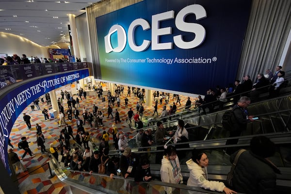 People attend the CES tech show Wednesday, Jan. 8, 2025, in Las Vegas. (AP Photo/John Locher)