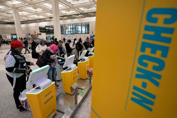 Passengers check-in for their flights at George Bush Intercontinental Airport Monday, Jan. 20, 2025, in Houston, ahead of a winter storm that will close both of Houston's airports Tuesday. (AP Photo/David J. Phillip))