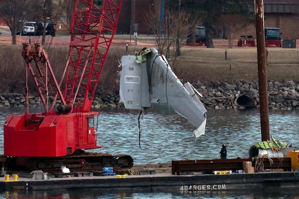 Rescue and salvage crews pull up airplane wreckage of an American Airlines jet in the Potomac River from Ronald Reagan Washington National Airport, Monday, Feb. 3, 2025, in Arlington, Va. (AP Photo/Jose Luis Magana)