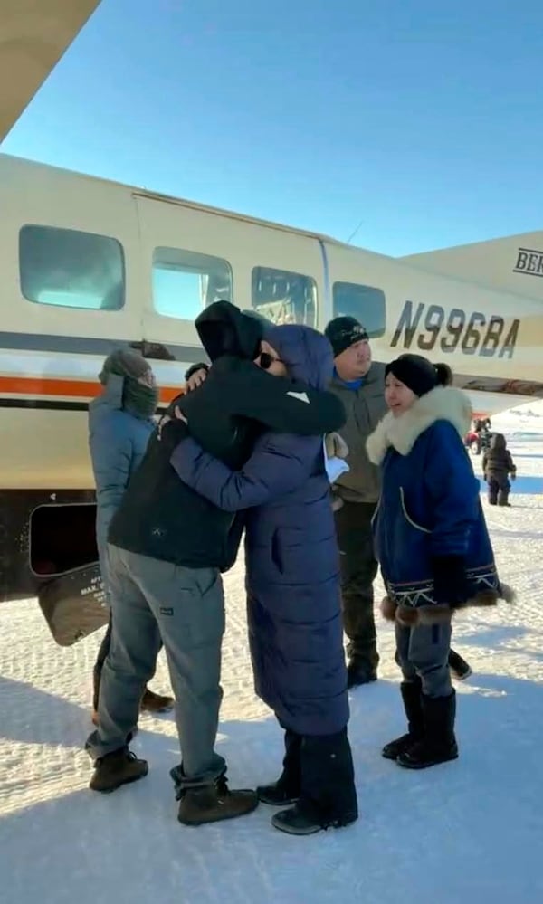 In this screen grab from a Facebook livestream, a Bering Air pilot is hugged by a resident of the Inupiat Eskimo village of Golovin in Alaska on Saturday, Feb. 8, 2025 (AP via Irene Navarro)