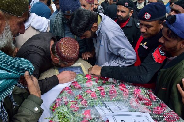 Mourners gather around a casket of a victim of a train attack, for a funeral prayer in Quetta, Pakistan's southwestern Balochistan province, Thursday March 13, 2025. (AP Photo/Arshad Butt)