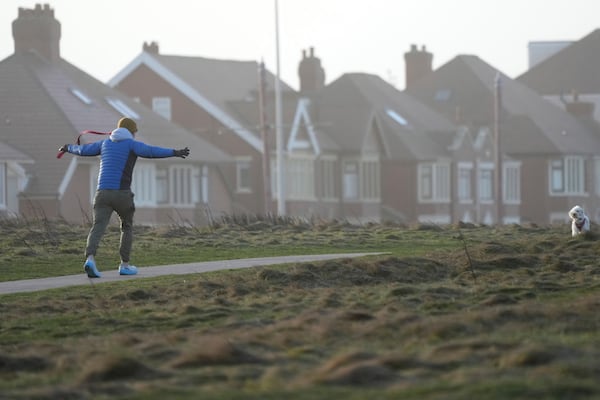 A man with his dog braves the wind as Storm Eowyn hits the country in Cleveleys, near Blackpool, England, Friday, Jan. 24, 2025.(AP Photo/Jon Super)