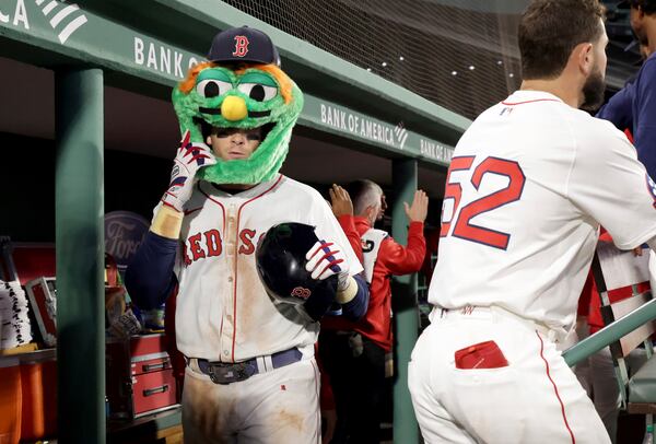 Boston Red Sox first baseman Triston Casas puts on a mascot head in the dugout while celebrating his three-run homerun during the eighth inning of a baseball game against the Seattle Mariners, Wednesday, April 23, 2025, in Boston. (AP Photo/Mark Stockwell)