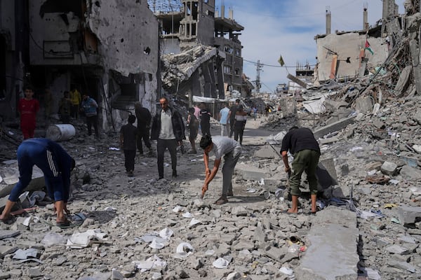 Palestinians clean the rubble along a road beside a clinic destroyed by Israeli airstrikes in Jabalia, in the northern Gaza Strip, on Thursday, May 15, 2025. (AP Photo/Jehad Alshrafi)