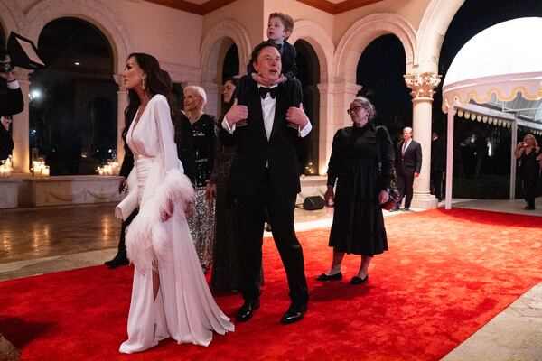 Elon Musk and his son, X AE A-Xii, arrive to a New Year's Eve party hosted by President-elect Donald Trump at Mar-a-Lago, Tuesday, Dec. 31, 2024, in Palm Beach, Fla. (AP Photo/Evan Vucci)