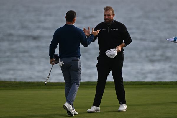 Rory McIlroy, of Northern Ireland, left, shakes hands with Shane Lowry after completing the 18th hole at Pebble Beach Golf Links during the final round of the AT&T Pebble Beach Pro-Am golf tournament, Sunday, Feb. 2, 2025, in Pebble Beach, Calif. (AP Photo/Nic Coury)