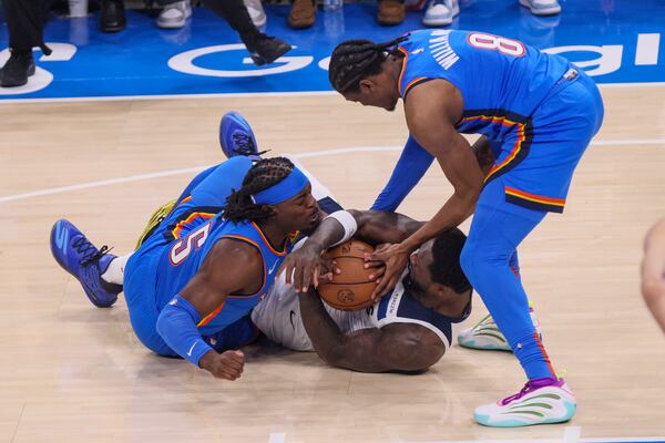 Minnesota Timberwolves forward Julius Randle, center, fights for the ball against Oklahoma City Thunder guard Luguentz Dort, left, and forward Jalen Williams during the first half of Game 2 of an NBA basketball Western Conference Finals playoff series Thursday, May 22, 2025, in Oklahoma City. (AP Photo/Nate Billings)