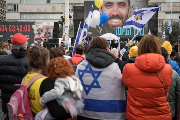 Israelis watch on a live broadcast as the first two of six hostages to be released in Gaza by Palestinian militants are handed over to the Red Cross, in 'Hostages Square' in Tel Aviv, Israel, Saturday Feb. 22, 2025. (AP Photo/Oded Balilty)