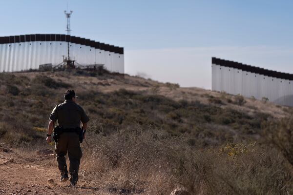 Border Patrol Agent Gutierrez walks towards a gap in one of two border walls separating Mexico from the United States, Thursday, Jan. 23, 2025, in San Diego. (AP Photo/Gregory Bull)