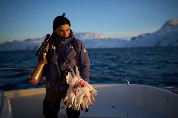 Bilo Chemnitz, 23, holds his rifle after hunting ptarmigan birds near the Nuuk fjord in Greenland, Monday, Feb. 17, 2025. (AP Photo/Emilio Morenatti)