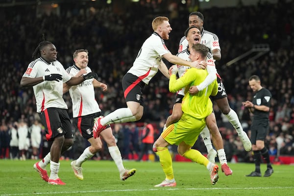 Fulham players celebrate after defeating Manchester United in a penalty shootout during the English FA Cup soccer match at the Old Trafford stadium in Manchester, England, Sunday, March 2, 2025. (AP Photo/Jon Super)