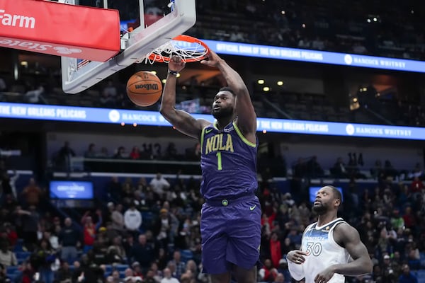 New Orleans Pelicans forward Zion Williamson (1) slam dunks ahead of Minnesota Timberwolves forward Julius Randle (30) in the second half of an NBA basketball game in New Orleans, Tuesday, Jan. 7, 2025. (AP Photo/Gerald Herbert)