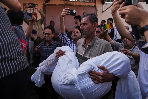 Mohammad Nassar carries the body of his nephew Jana Nassar killed in an Israeli army airstrike on the Gaza Strip, during his funeral at Al-Aqsa Hospital in Deir al-Balah, Gaza, Tuesday, May 20, 2025. (AP Photo/Abdel Kareem Hana)