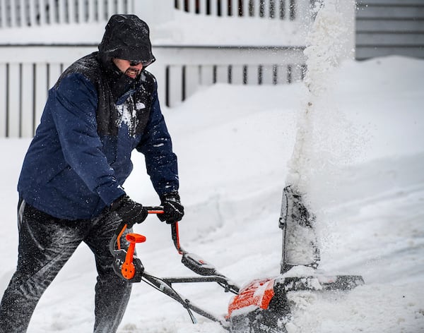 Chris Crowley struggles with heavy, wet snow Sunday afternoon, Feb. 16, 2025, as wind and driving sleet made conditions difficult to remove snow from a driveway on Shawmut Street in Lewiston, Maine. (Russ Dillingham/Sun Journal via AP)