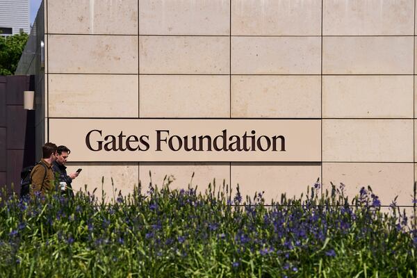 People walk by a Gates Foundation sign at the foundation's campus Wednesday, April 30, 2025, in Seattle. (AP Photo/Lindsey Wasson)