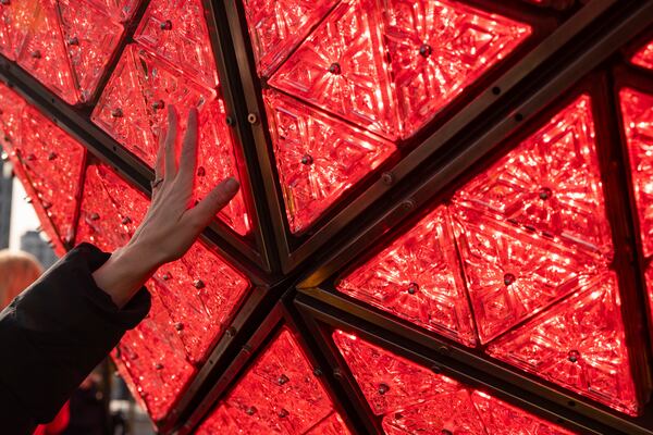 A person touches the Times Square New Year's Eve Ball at One Times Square, Friday, Dec. 27, 2024, in New York. (AP Photo/Yuki Iwamura)