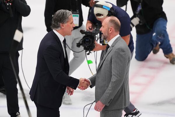 Colorado Avalanche head coach Jared Bednar, left, and Dallas Stars head coach Pete DeBoer, right, greet each other on the ice after their team's Game 7 of a first-round NHL hockey playoff series Saturday, May 3, 2025, in Dallas. (AP Photo/Julio Cortez)