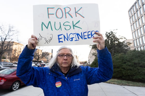 Cindy Nell, of Cheverly, Md., holds a banner during a rally in front of the Office of Personnel Management, Monday, Feb. 3, 2025, in Washington. President Donald Trump is relying on a relatively obscure federal agency to reshape government. The Office of Personnel Management was created in 1979 by President Jimmy Carter and is the equivalent of the government's human resources department. It helps manage the civil service, including pay schedules, health insurance and pension programs. The agency has offered millions of federal workers eight months of salary if they voluntarily choose to leave their jobs by Feb. 6. (AP Photo/Manuel Balce Ceneta)