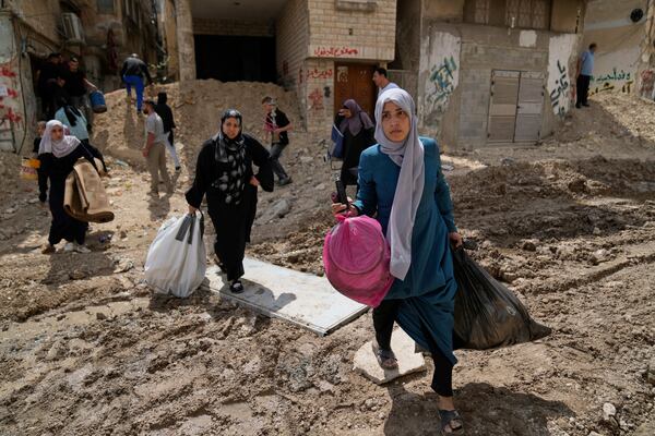 Residents of the now evacuated refugee camp of Tulkarem return to collect belongings before the destruction of their homes as Israeli forces prepare to carry out the demolition of 116 homes across the two refugee camps of the Israeli occupied West Bank city of Tulkarem, Friday, May 2, 2025. (AP Photo/Nasser Nasser)