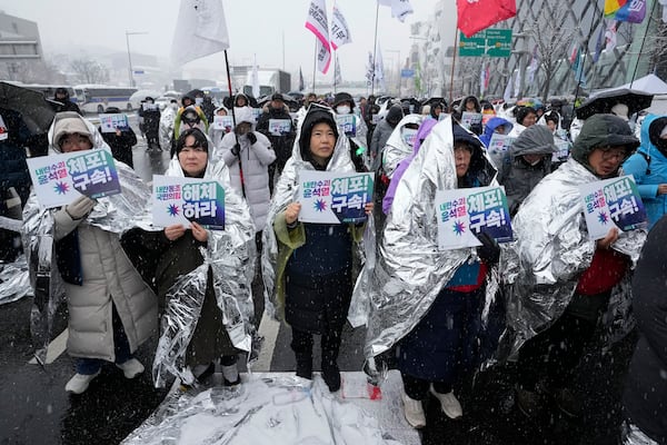 Protesters attend a rally demanding the arrest of impeached South Korean President Yoon Suk Yeol near the presidential residence in Seoul, South Korea, Sunday, Jan. 5, 2025. Banners read "Disband the ruling People Power Party," second left, and "Arrest Yoon Suk Yeol." (AP Photo/Ahn Young-joon)