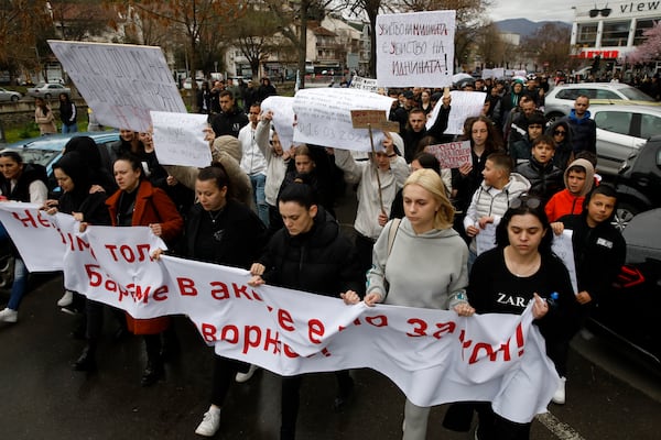 Protesters hold placards as they march during protest following a massive nightclub fire in the town of Kocani, North Macedonia, Monday, March 17, 2025. (AP Photo/Boris Grdanoski)