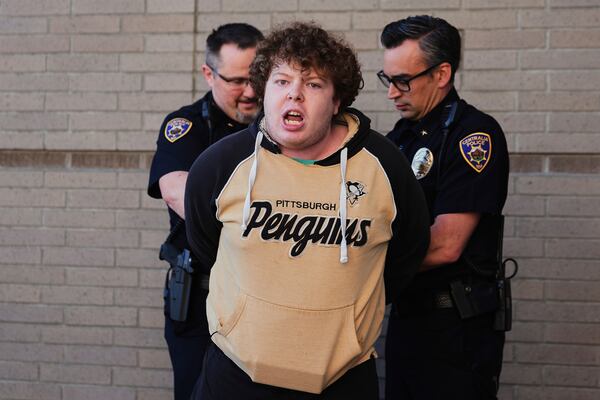 A protester is arrested by Centralia police officers at a town hall event with Rep. Marie Gluesenkamp Perez, D-Wash., at Centralia College, Tuesday, April 22, 2025, in Centralia, Wash. (AP Photo/Lindsey Wasson)