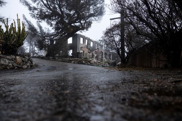 A fire-damaged property is seen in the Eaton Fire zone during a storm Thursday, Feb. 13, 2025, in Altadena, Calif. (AP Photo/Etienne Laurent)