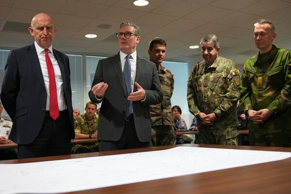 Britain's Prime Minister Keir Starmer and John Healey, Secretary of State for Defence, center left, look at a Ukraine map as they visit a military base to meet planners mapping out next steps in the Coalition of the Willing in Northwood, London, Thursday, March 20, 2025.(AP Photo/Alastair Grant, Pool)