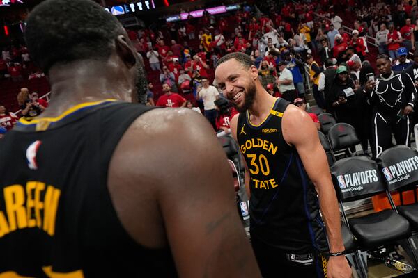 Golden State Warriors' Stephen Curry (30) and Draymond Green celebrate after Game 7 of an NBA basketball first-round playoff series against the Houston Rockets Sunday, May 4, 2025, in Houston. (AP Photo/Ashley Landis)