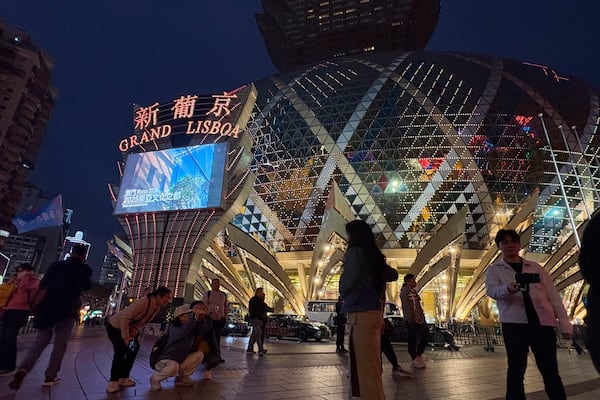 Tourists take photos outside the Grand Lisboa casino on Dec. 13, 2024. (AP Photo/Kanis Leung)