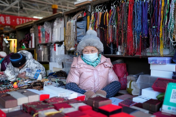 A senior woman waits for customers at a market in Beijing, Thursday, Jan. 16, 2025. (AP Photo/Aaron Favila)