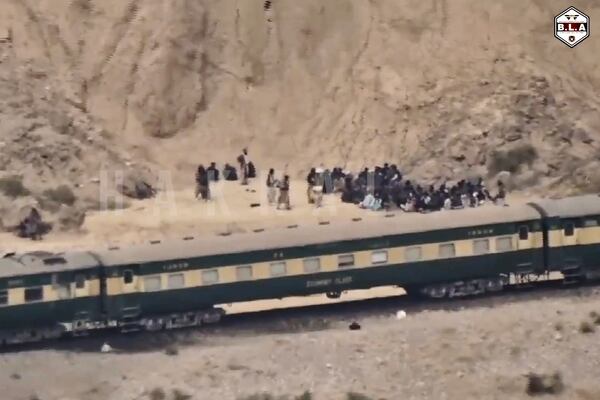 In this frame grab from a video released by the Baluchistan Liberation Army shows people outside the a train after being attacked by the BLA on its transit from Quetta to the northern city of Peshawar, in Bolan district, Pakistan's southwestern Balochistan province, March 12, 2025..(BLA via AP)