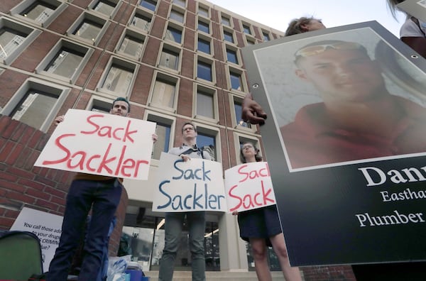 FILE - Protesters gather outside a courthouse on Friday, Aug. 2, 2019, in Boston, where a judge was to hear arguments in Massachusetts' lawsuit against Purdue Pharma over its role in the national drug epidemic. (AP Photo/Charles Krupa, File)