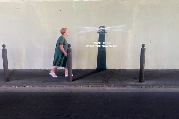 A woman walks past an artwork by street artist Banksy, Friday, May 30, 2025 in Marseille, southern France. (AP Photo/Bishr Eltoni)