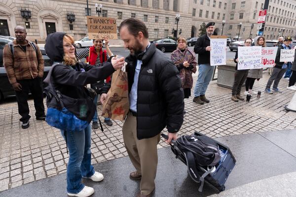 United States Agency for International Development (USAID) worker Donato Corsini carries personal belongings after retrieving them from USAID's headquarters in Washington, Thursday, Feb. 27, 2025. (AP Photo/Manuel Balce Ceneta)