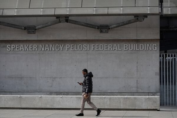 A pedestrian walks by the Speaker Nancy Pelosi Federal Building in San Francisco, Tuesday, March 4, 2025. (AP Photo/Godofredo A. Vásquez)