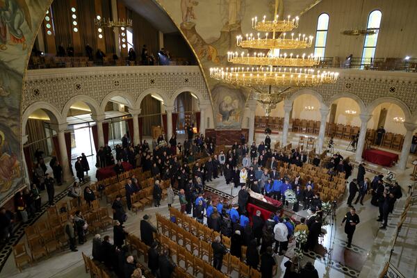 People pay their respects to the late Archbishop Anastasios of Tirana, Durres and All Albania during a religious ceremony, a day before his funeral, inside the Cathedral of the Resurrection of Christ, in Tirana, Albania, Wednesday, Jan. 29, 2025. (AP Photo/Vlasov Sulaj)