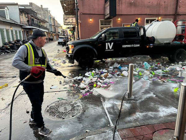 An employee of IV Waste, the company tasked with cleaning up New Orleans' French Quarter, pressure washes a street on Ash Wednesday, March 5, 2025, the day after Mardi Gras. (AP Photo/Jack Brook)