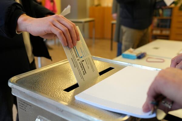 A resident casts a vote at a polling station in Berlin, Germany, Sunday, Feb. 23, 2025, during the German national election. (AP Photo/Markus Schreiber)