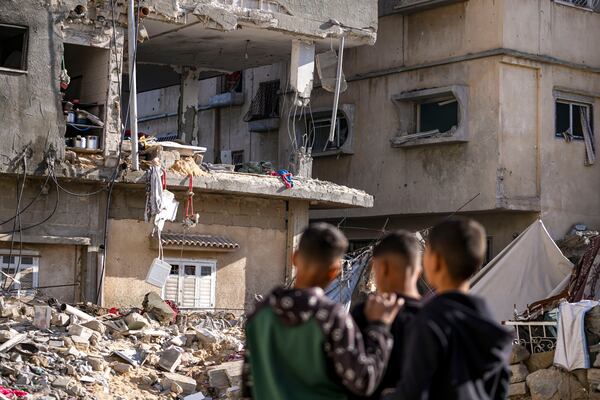 FILE - Palestinians look at a damaged residential building following an overnight Israeli strike in Deir al-Balah, Gaza Strip, Wednesday, Jan. 8, 2025. (AP Photo/Abdel Kareem Hana, File)