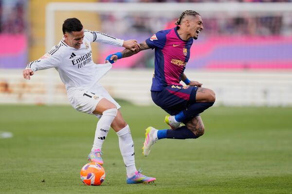 Barcelona's Raphinha, right, and Real Madrid's Lucas Vazquez fight for the ball during the Spanish La Liga soccer match between Barcelona and Real Madrid at the Lluis Companys Olympic Stadium in Barcelona, Spain, Sunday, May 11, 2025. (AP Photo/Jose Breton)
