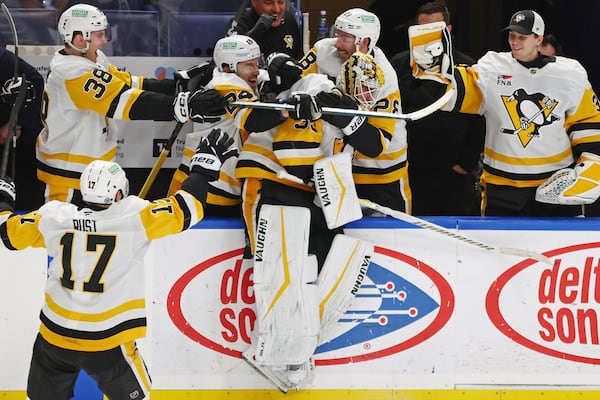 Pittsburgh Penguins goaltender Alex Nedeljkovic, center, celebrates with teammates after scoring during the third period of an NHL hockey game against the Buffalo Sabres, Friday, Jan. 17, 2025, in Buffalo, N.Y. (AP Photo/Jeffrey T. Barnes)